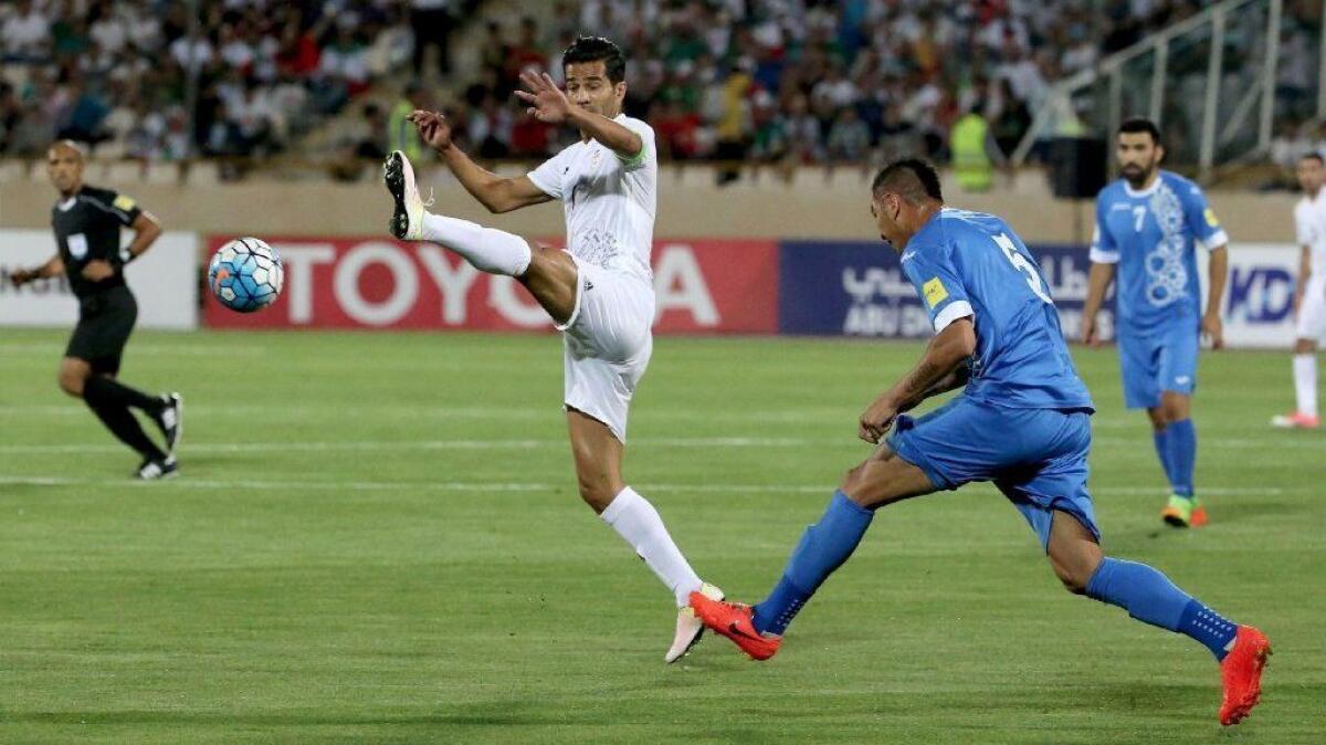 Iran's Masoud Shojaei, shown at left in a World Cup qualifying match against Uzbekistan, is one of two players barred from Iran's national team.