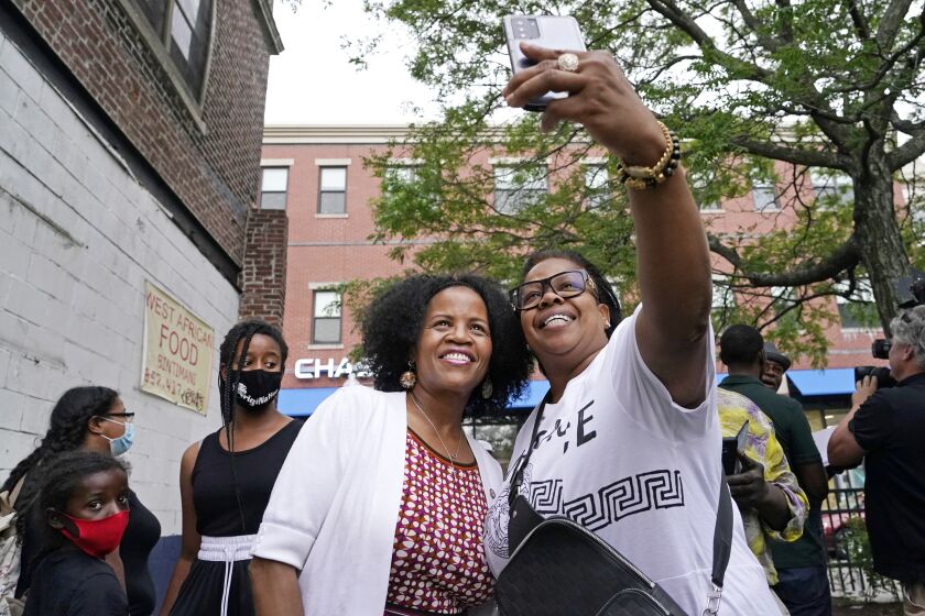 Boston's acting Mayor Kim Janey, left, takes a selfie with Mikey Miles as she meets people in Boston's Nubian Square for a Juneteenth commemoration, Friday, June 18, 2021, in Boston. (AP Photo/Elise Amendola)