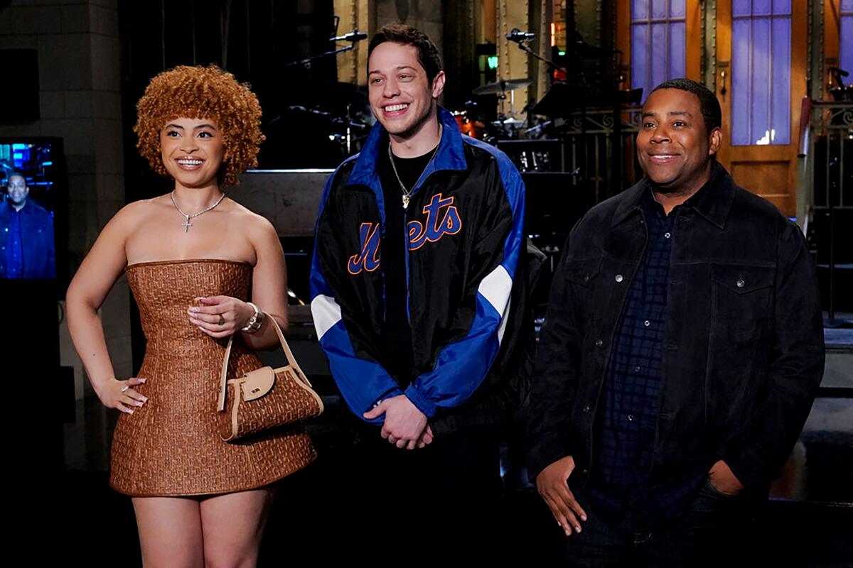 Ice Spice, Pete Davidson and Kenan Thompson stand and smile on the set of "Saturday Night Live."