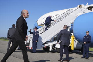 President Trump walks up boarding stairs toward Air Force One on a tarmac