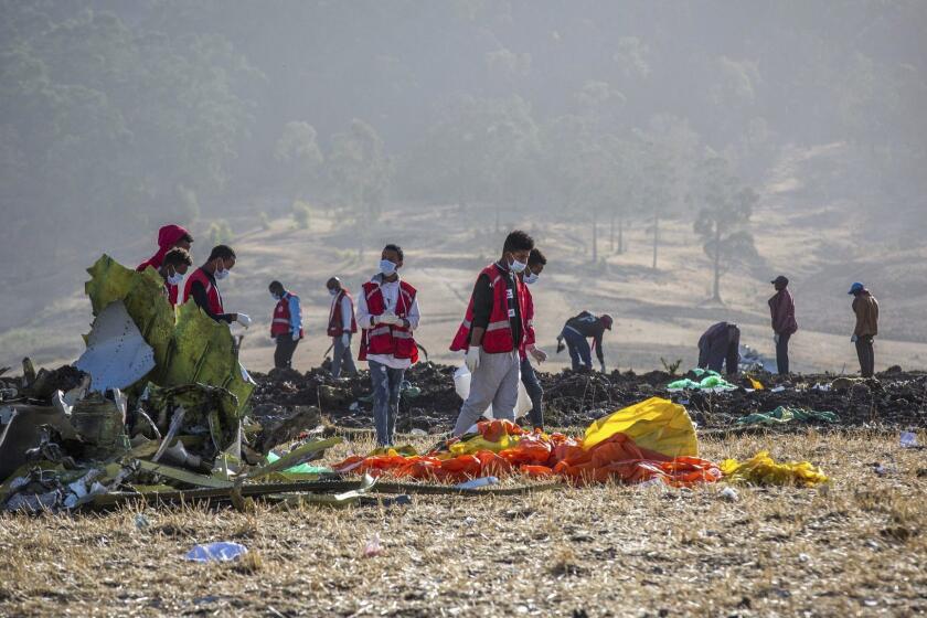 FILE- In this March 11, 2019, file photo rescuers work at the scene of an Ethiopian Airlines flight crash near Bishoftu, or Debre Zeit, south of Addis Ababa, Ethiopia. Investigators have determined that an anti-stall system automatically activated before the Ethiopian Airlines Boeing 737 Max jet plunged into the ground, The Wall Street Journal reported Friday, March 29. (AP Photo/Mulugeta Ayene, File)