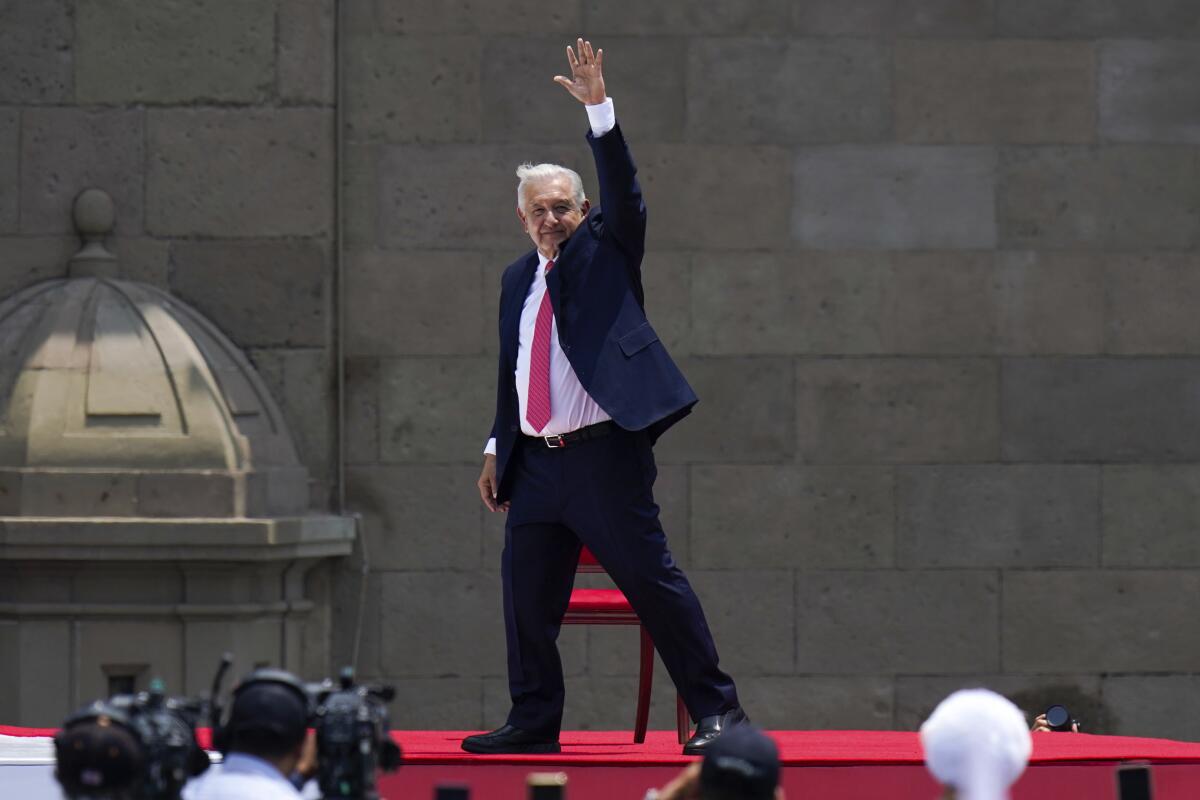 Mexican President Andrés Manuel López Obrador waves on a stage in Mexico City's Zocalo