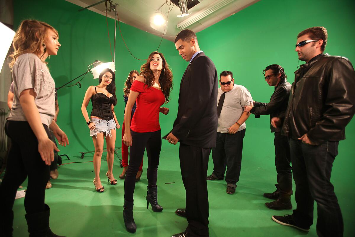 Actors and production staff rehearse for a music video shoot on a green screen set at Maker Studios in 2011.