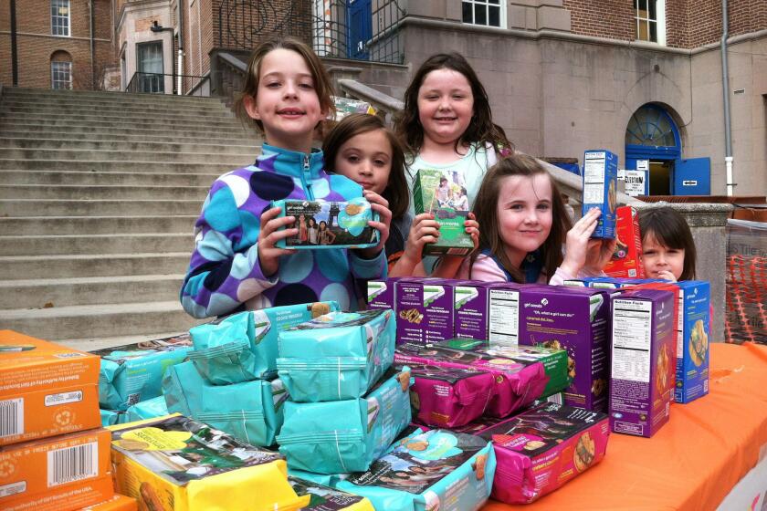 Girl Scouts sell boxes of cookies. The organization announced the release of three new cookie flavors this year, including two gluten-free varieties.
