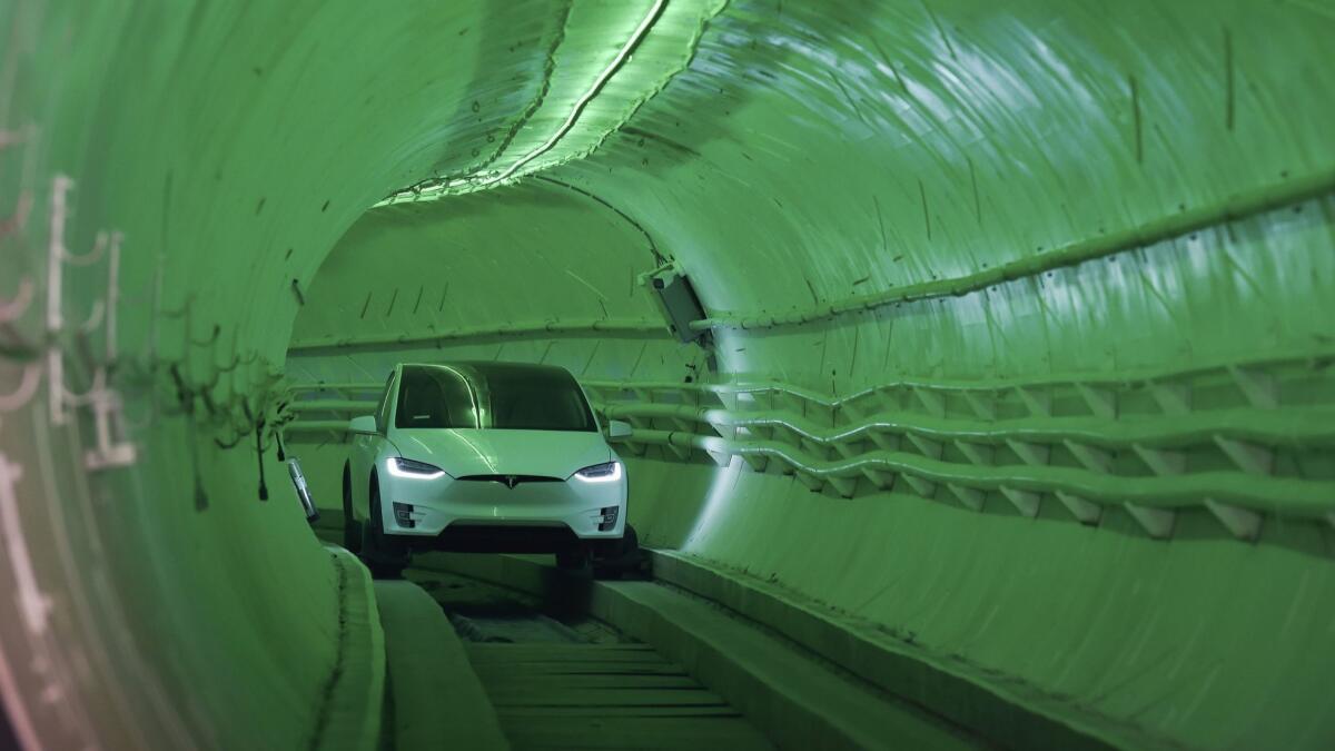 At an unveiling Tuesday in Hawthorne for Boring Co.'s first tunnel, Elon Musk arrived in a modified Tesla Model X that steered along the bumpy subterranean track using guide wheels.