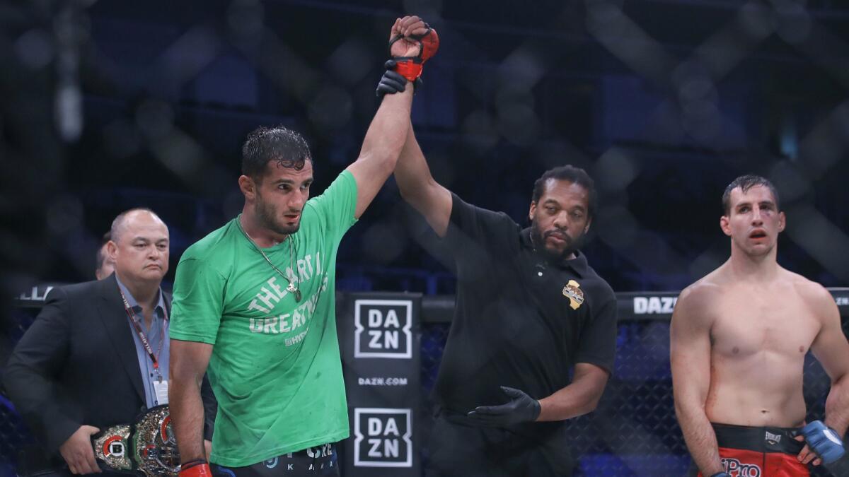 Gegard Mousasi, second from left, has his arm raised by referee Herb Dean after defeating Rory MacDonald, right, during a middleweight world title mixed martial arts bout at Bellator 206 in San Jose on Saturday.