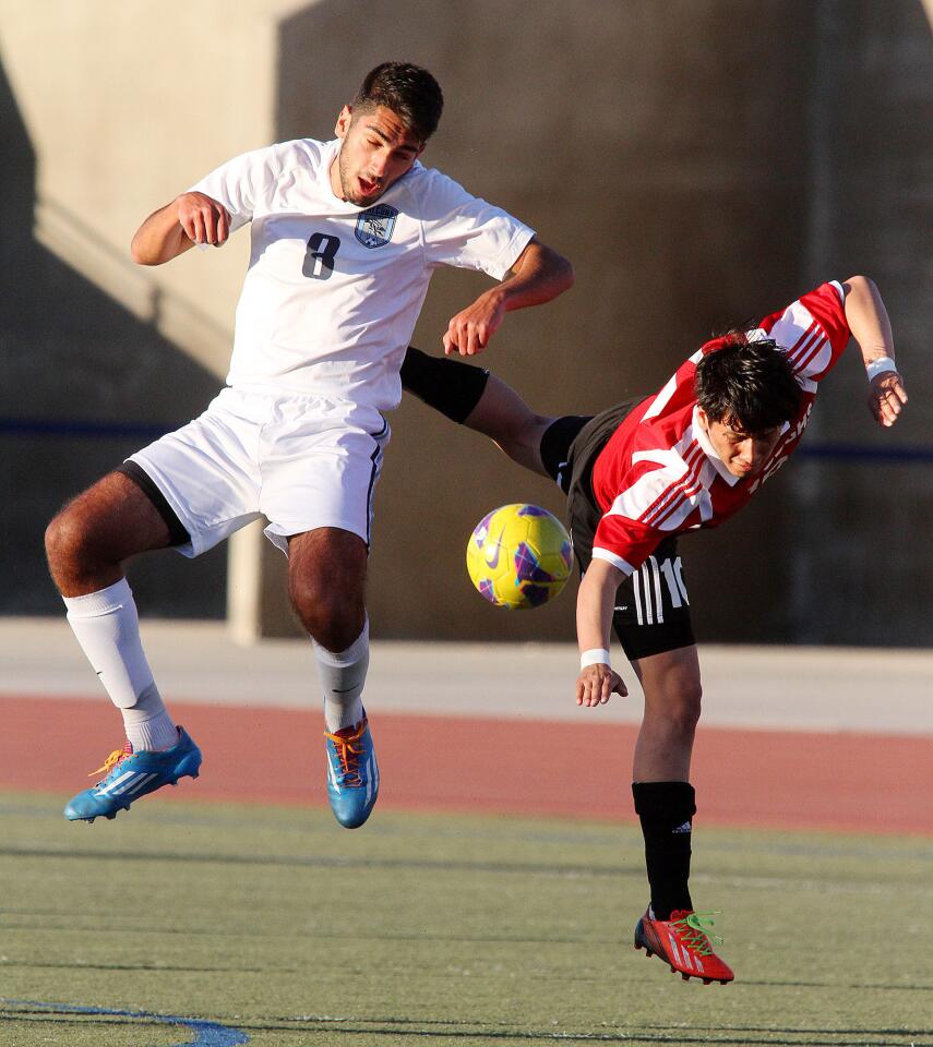 Crescenta Valley's Kevin Ginosian battles against Burroughs' Nolberto Alcantar for control of the ball in a Pacific League boys soccer game at Crescenta Valley High School on Monday, January 13, 2014. (Tim Berger/Staff Photographer)