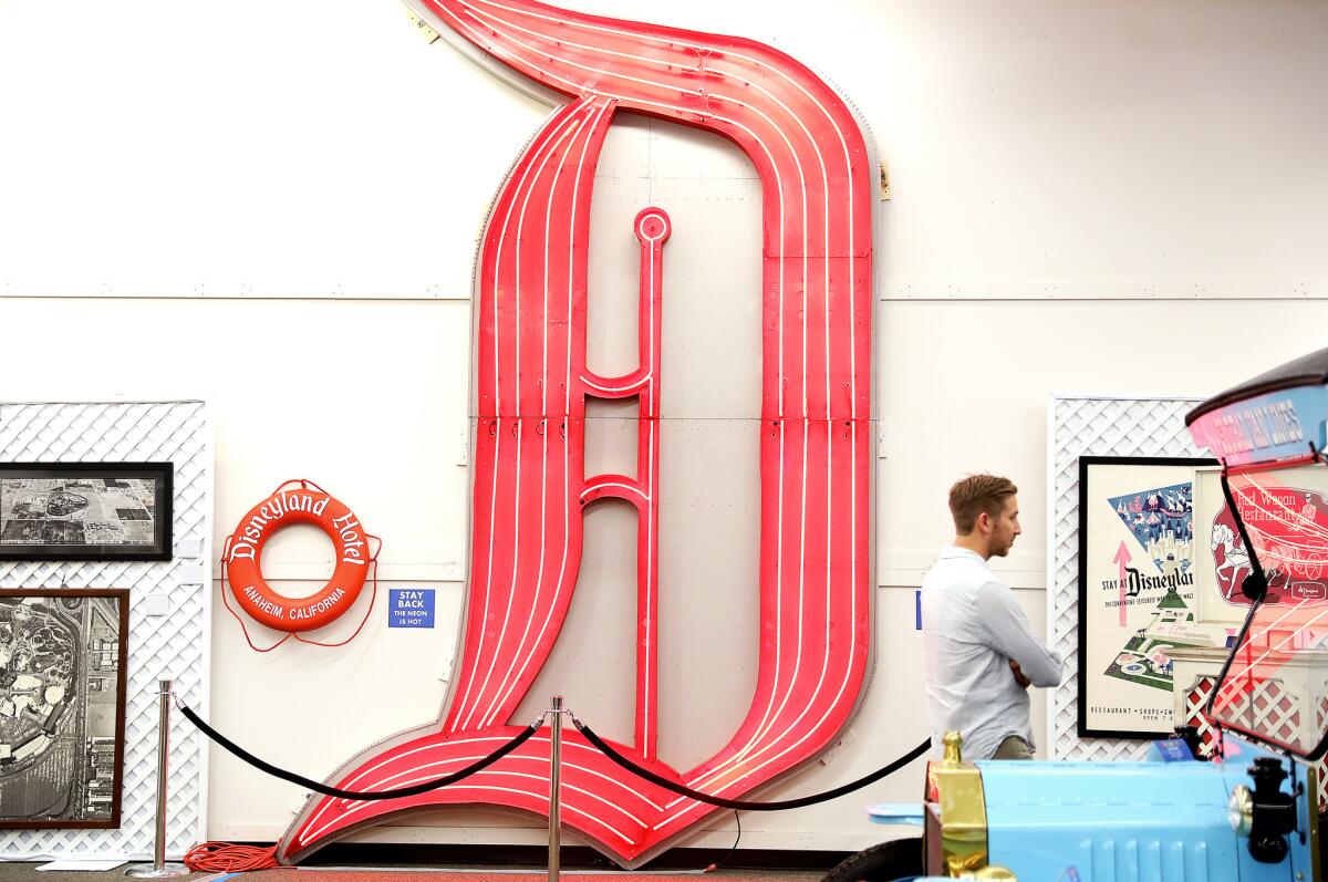Nicholas Kraft stands beside the neon "D" from the Disneyland Hotel, part of the Kraftland Collection that is going up for auction.