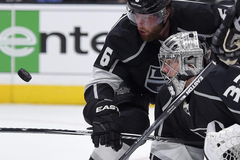 Kings goalie Jonathan Quick, lower right, tries to stop a shot along with defenseman Jake Muzzin against the Chicago Blackhawks on Jan. 28 at Staples Center.