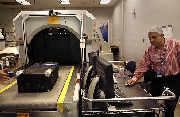 Engineer Jagdeep Talwar sends a bag through a detection machine at the Transportation Security Lab, where scientists test how well airport security devices can pick up on explosives.