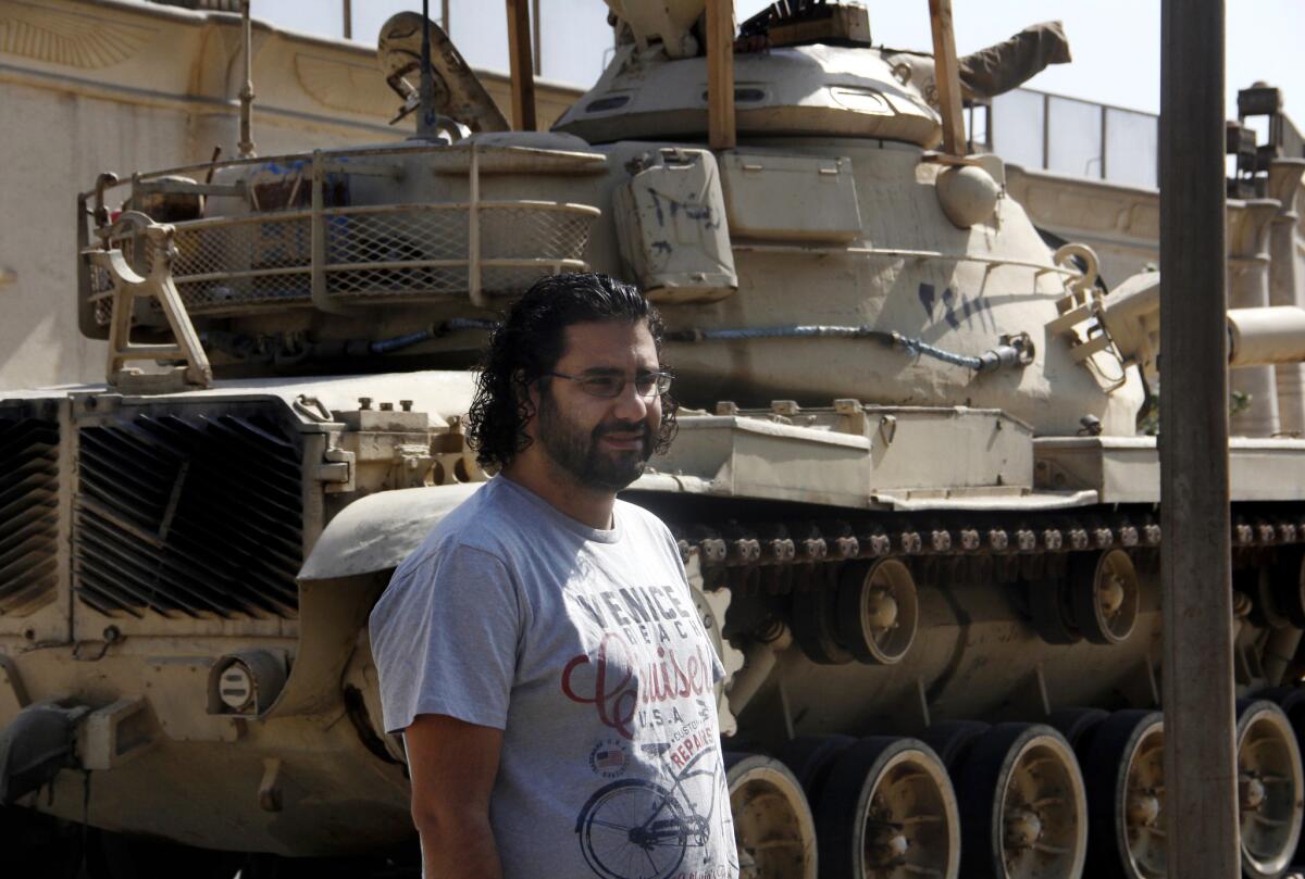Prominent Egyptian activist Alaa Abdel Fattah stands in front of a criminal court in Cairo on Wednesday. A court convicted him of demonstrating without a permit and assaulting a police officer, sentencing him to 15 years in prison.