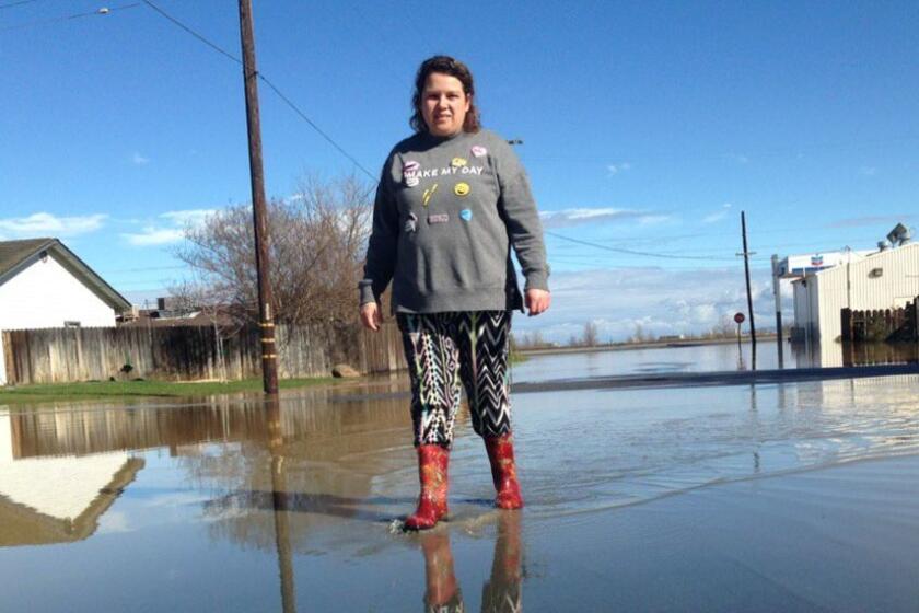 Blanca Velasquez was among many searching for dry ground Saturday in the flooded town of Maxwell, south of Oroville.
