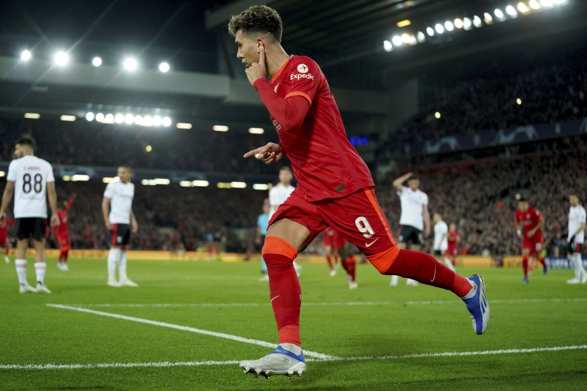 Liverpool's Roberto Firmino celebrates scoring his side's third goal during the Champions League quarterfinal second leg soccer match between Liverpool and Benfica, at Anfield stadium in Liverpool, England, Wednesday, April 13, 2022. (AP Photo/Jon Super)