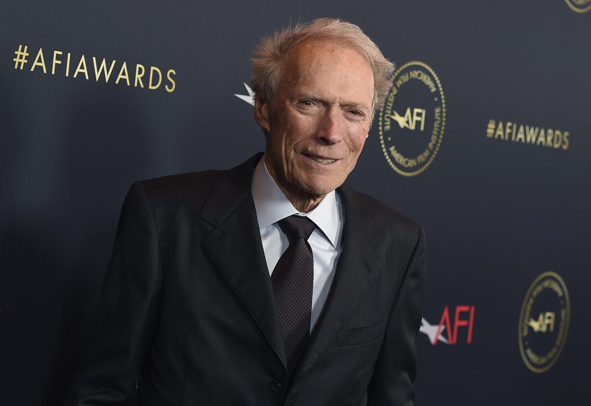 An older man dressed in a dark suit and tie and white shirt