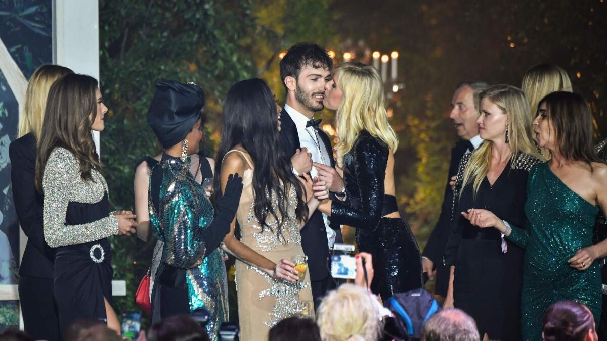 Czech model Karolina Kurkova kisses the winner of an auction at the afAR gala.