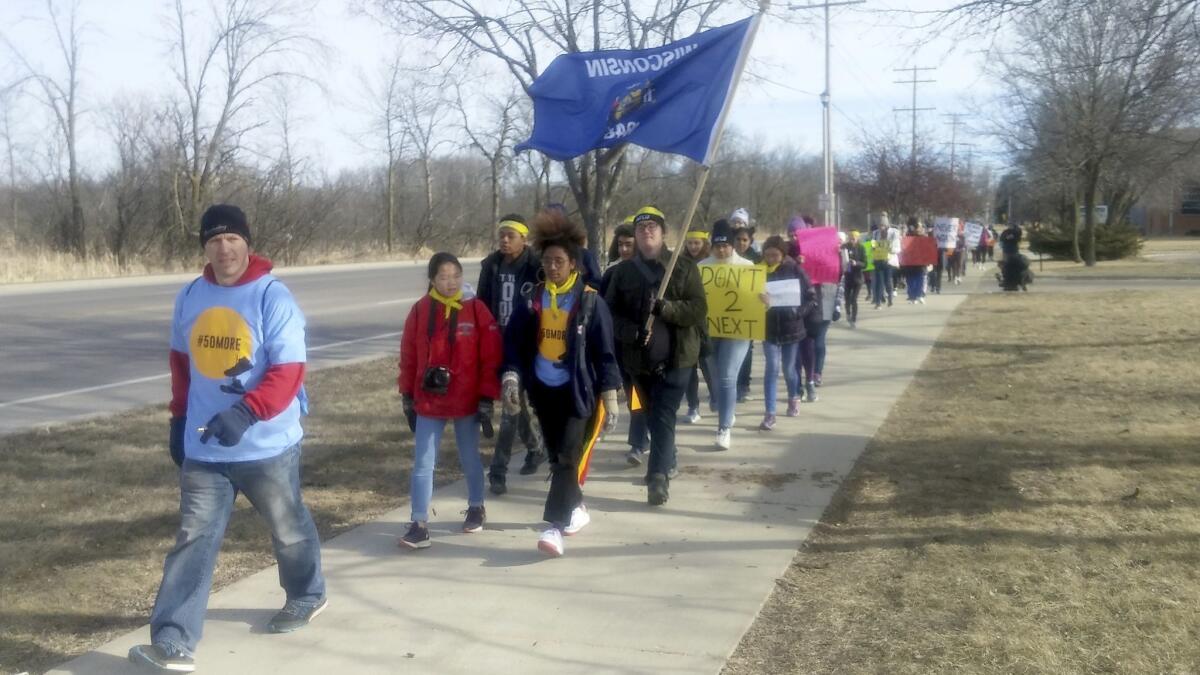 About 40 students from across Wisconsin march as part of a 50 Miles More event to protest gun violence and advocate for gun control.