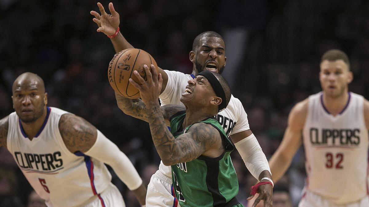 Celtics guard Isaiah Thomas struggles to get the ball past Clippers guard Chris Paul during fourth quarter action.