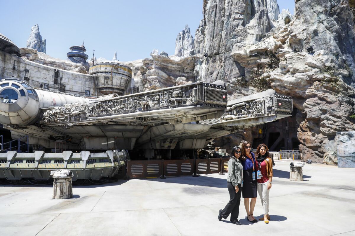 Disneyland Resort cast members pose for a photo in front of The Millennium Falcon: Smugglers Run ride, inside the new "Star Wars: Galaxy's Edge," at Disneyland Resort.
