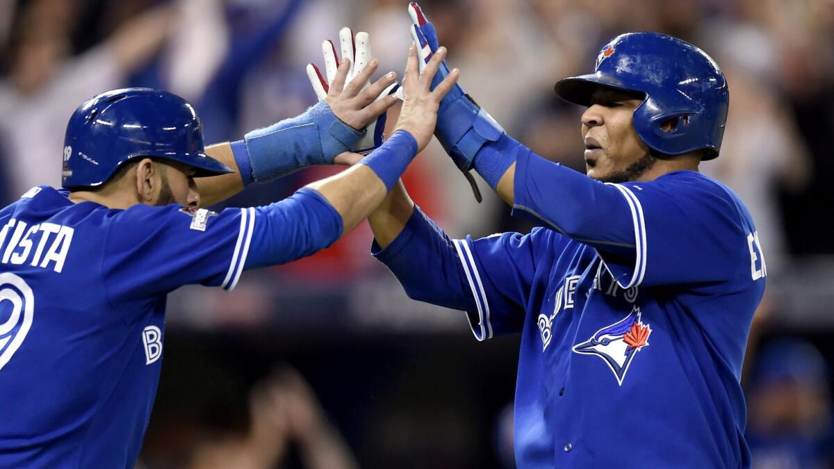 Blue Jays right fielder Jose Bautista, left, and designated hitter Edwin Encarnacion celebrate after scoring on a three-run double by Troy Tulowitzki in the sixth inning in Game 5 of the ALCS.