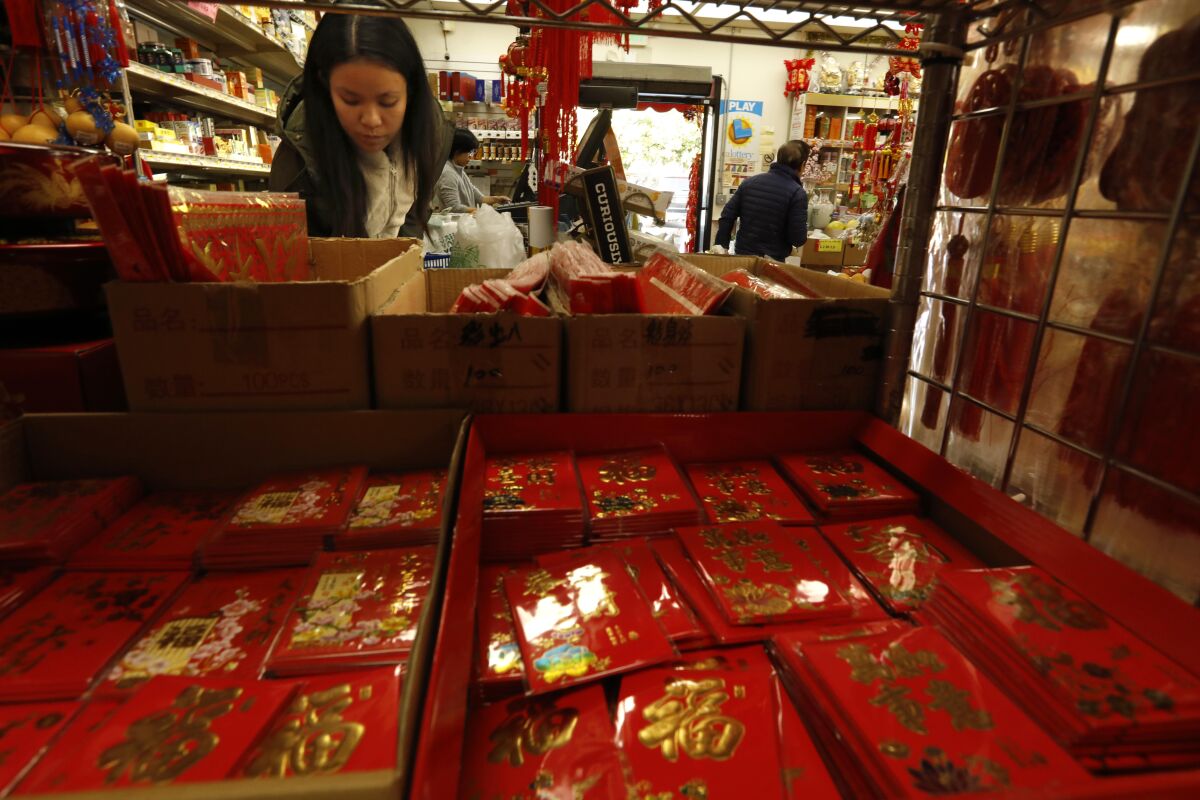 Shoppers look for decorations, red envelopes and other items for Lunar New Year celebrations at a market.