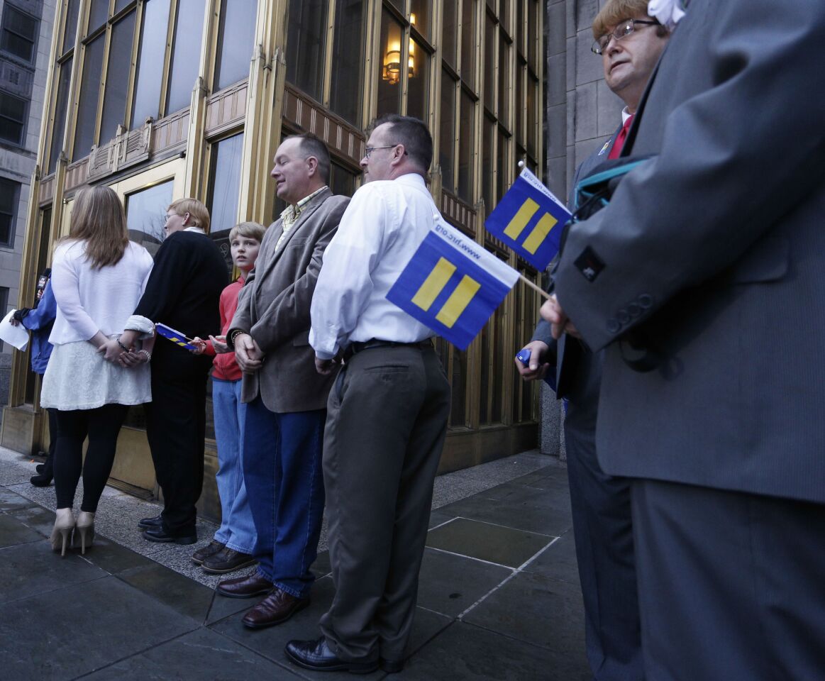 Same-sex couples wait for the Jefferson County courthouse to open so they can be legally married in Birmingham, Ala.