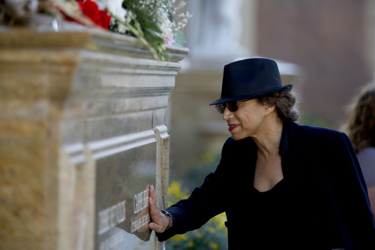 After the memorial, friend Shari Wilson of Los Angeles touches the Debbie Reynolds and Carrie Fisher grave site at Forest Lawn Memorial Park-Hollywood.