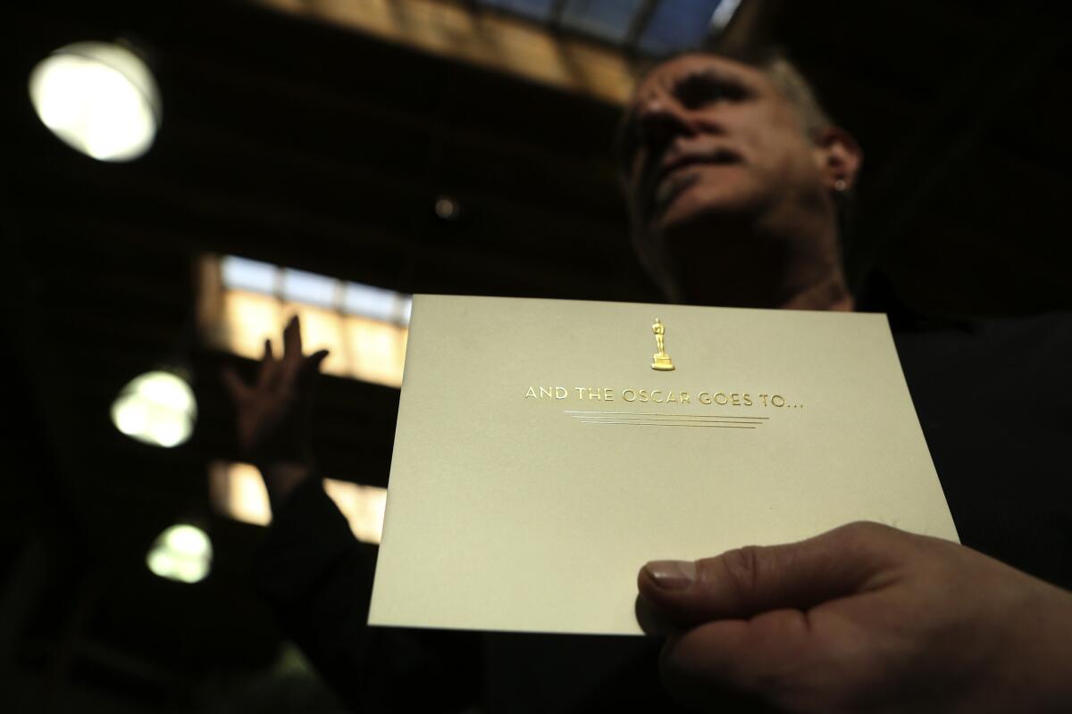 Marc Friedland holds the card that is placed inside each Oscar envelope.