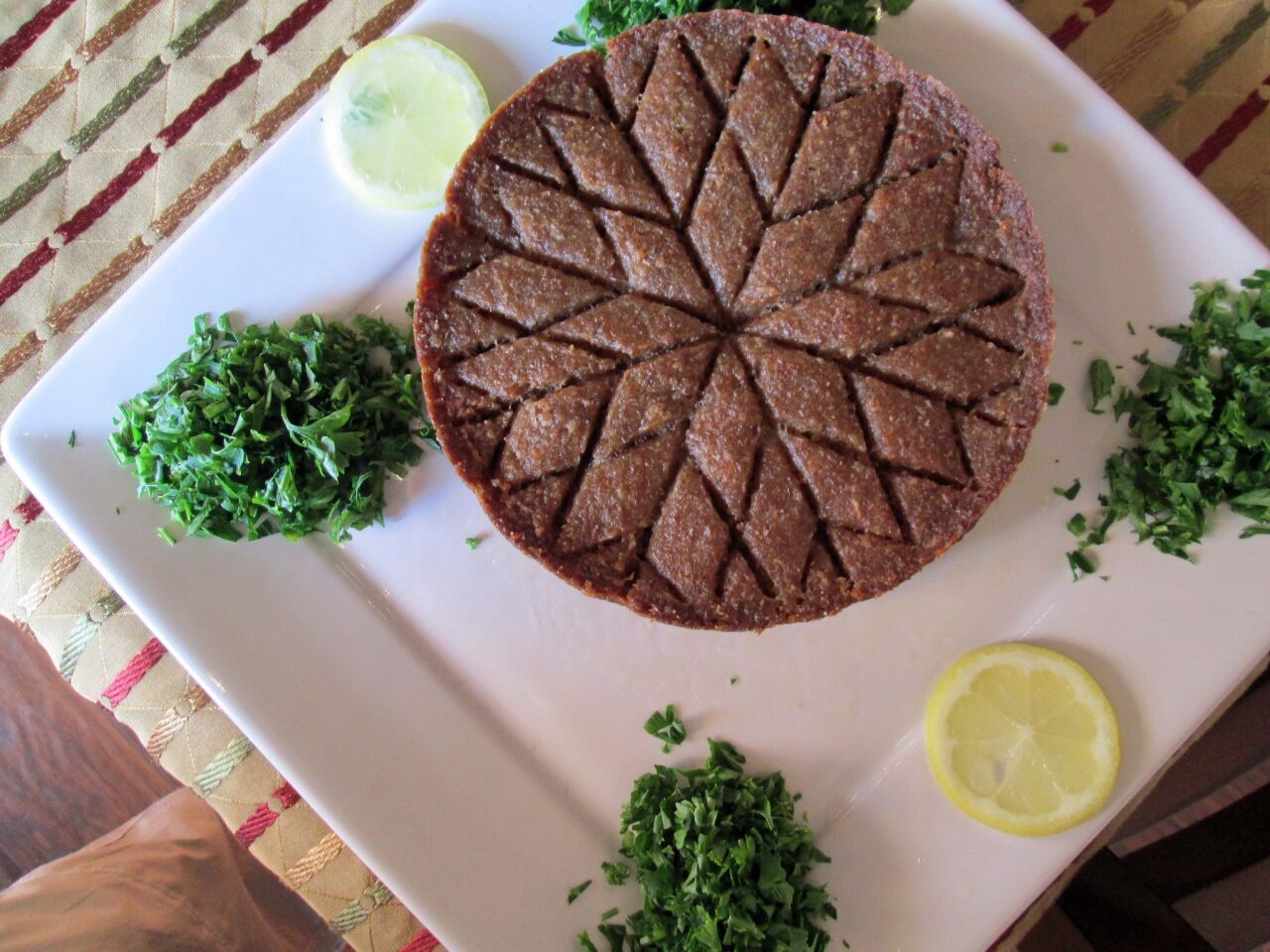 Kibbeh bil seniyeh is baked in a pan.