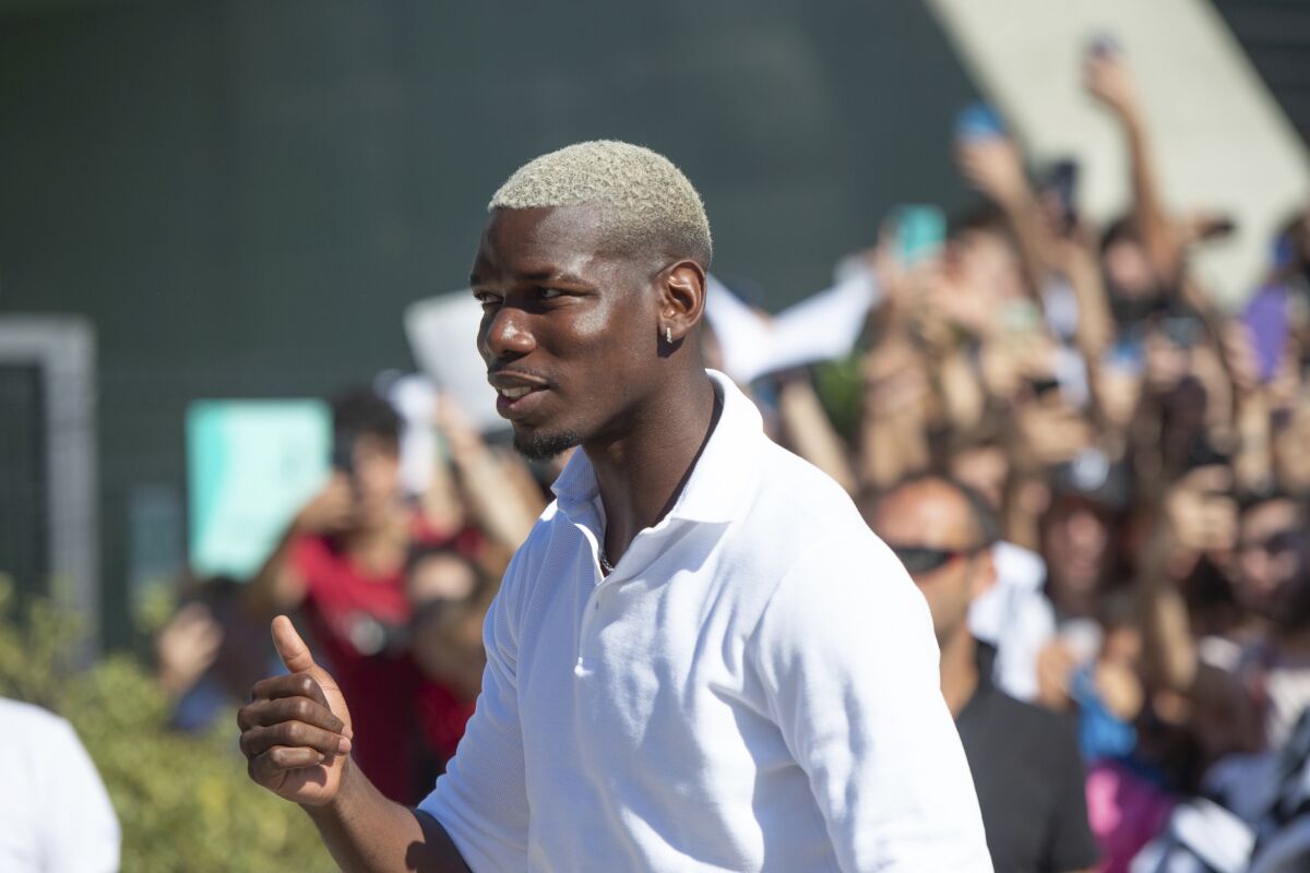 Midfielder Paul Pogba gives the thumbs up as he arrives at Juve's Medical Center, in Turin, northern Italy, Saturday, July 9, 2022. More than 1,000 fans welcomed Paul Pogba back home as he returned to Juventus on a free transfer from Manchester United on Saturday. (LaPresse via AP)