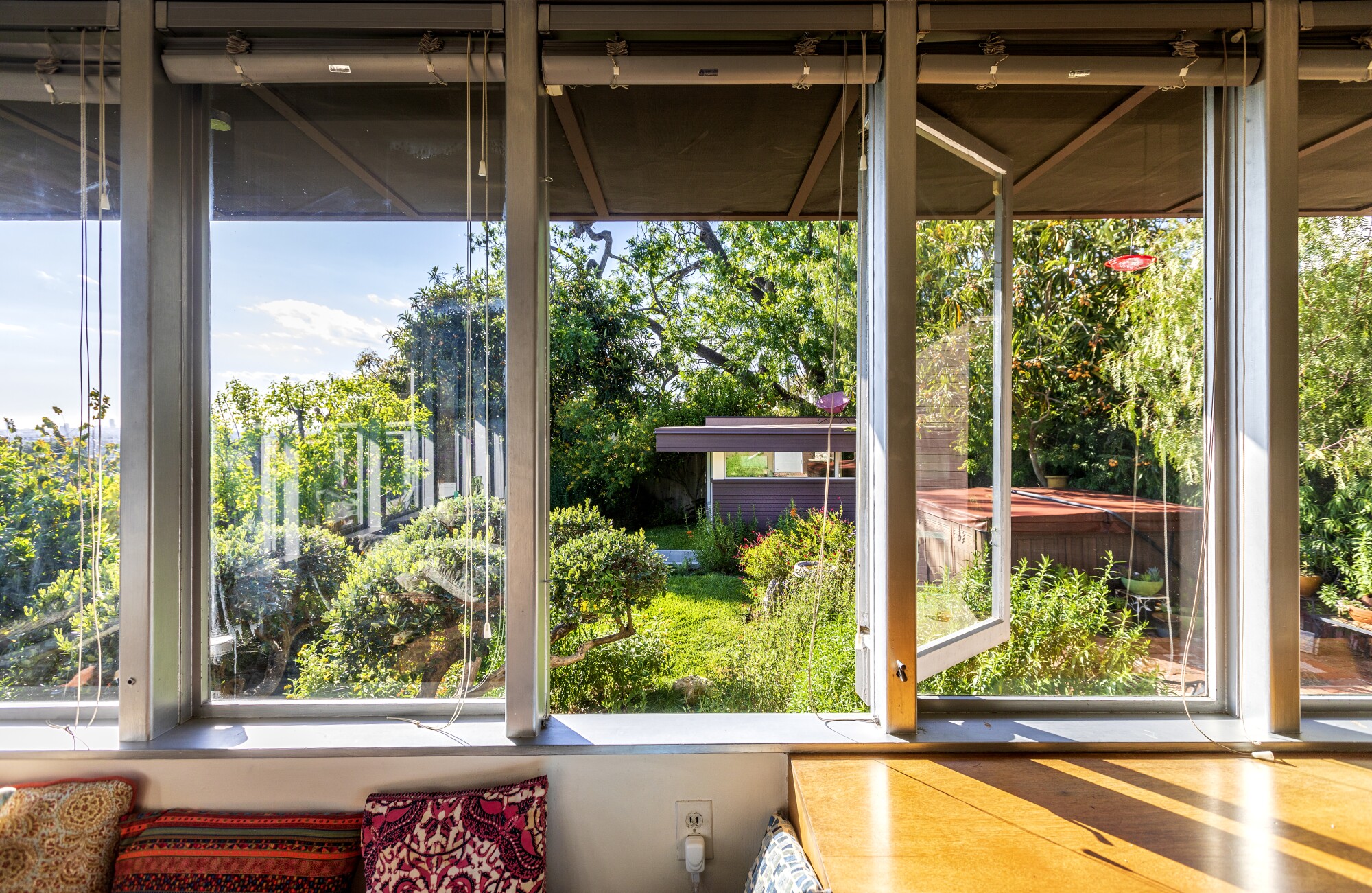 A view of a small building, in a garden, through windows