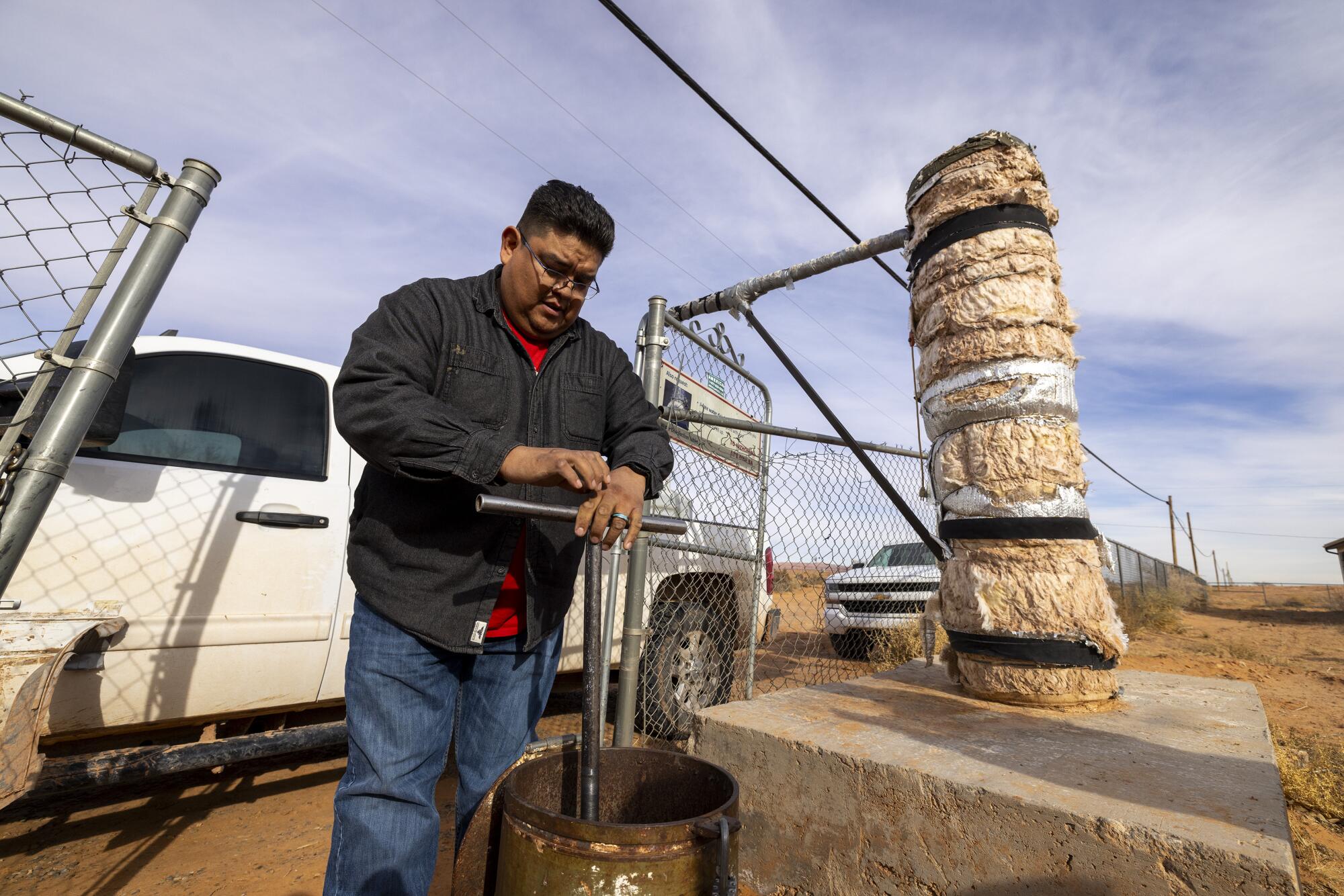 Leland Interpreter turns the valve at a well at the Dennehotso Chapter House.