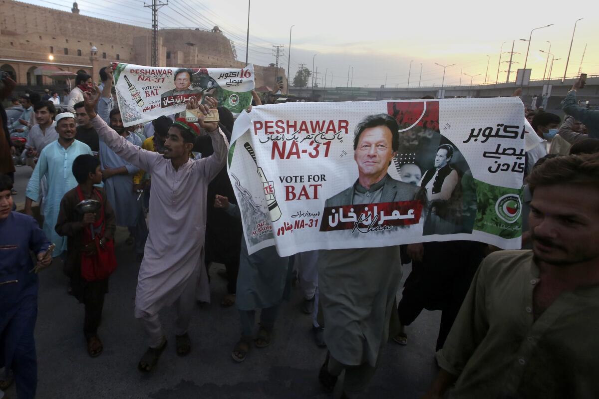 Supporters of former Pakistani Prime Minister Imran Khan holding banners