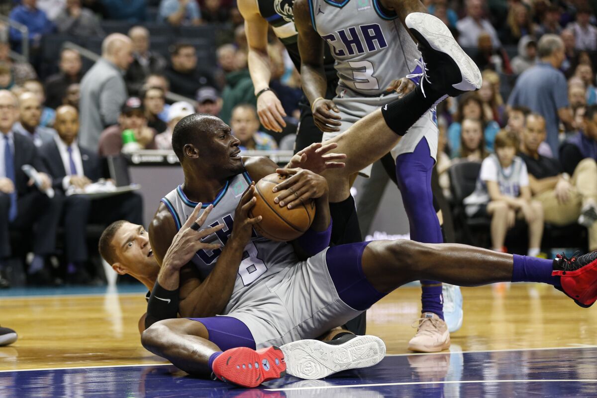 Charlotte Hornets center Bismack Biyombo, front, battles Milwaukee Bucks center Brook Lopez for the ball in the second half of an NBA basketball game in Charlotte, N.C., Sunday, March 1, 2020. (AP Photo/Nell Redmond)
