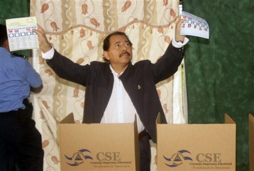 Nicaragua's President Daniel Ortega shows his ballots to reporters before casting them during municipal elections in Managua, Sunday, Nov. 9, 2008. (AP Photo/Arnulfo Franco)