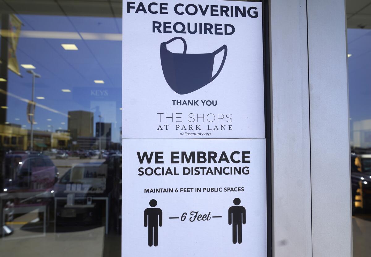 Signs tells customers about safety measures against COVID-19 that are required inside a retail store Tuesday, March 2, 2021, in Dallas. Texas is lifting a COVID-19 mask mandate that was imposed last summer but has only been lightly enforced. Republican Gov. Greg Abbott’s announcement Tuesday makes Texas the largest state to do away with a face covering order. (AP Photo/LM Otero)