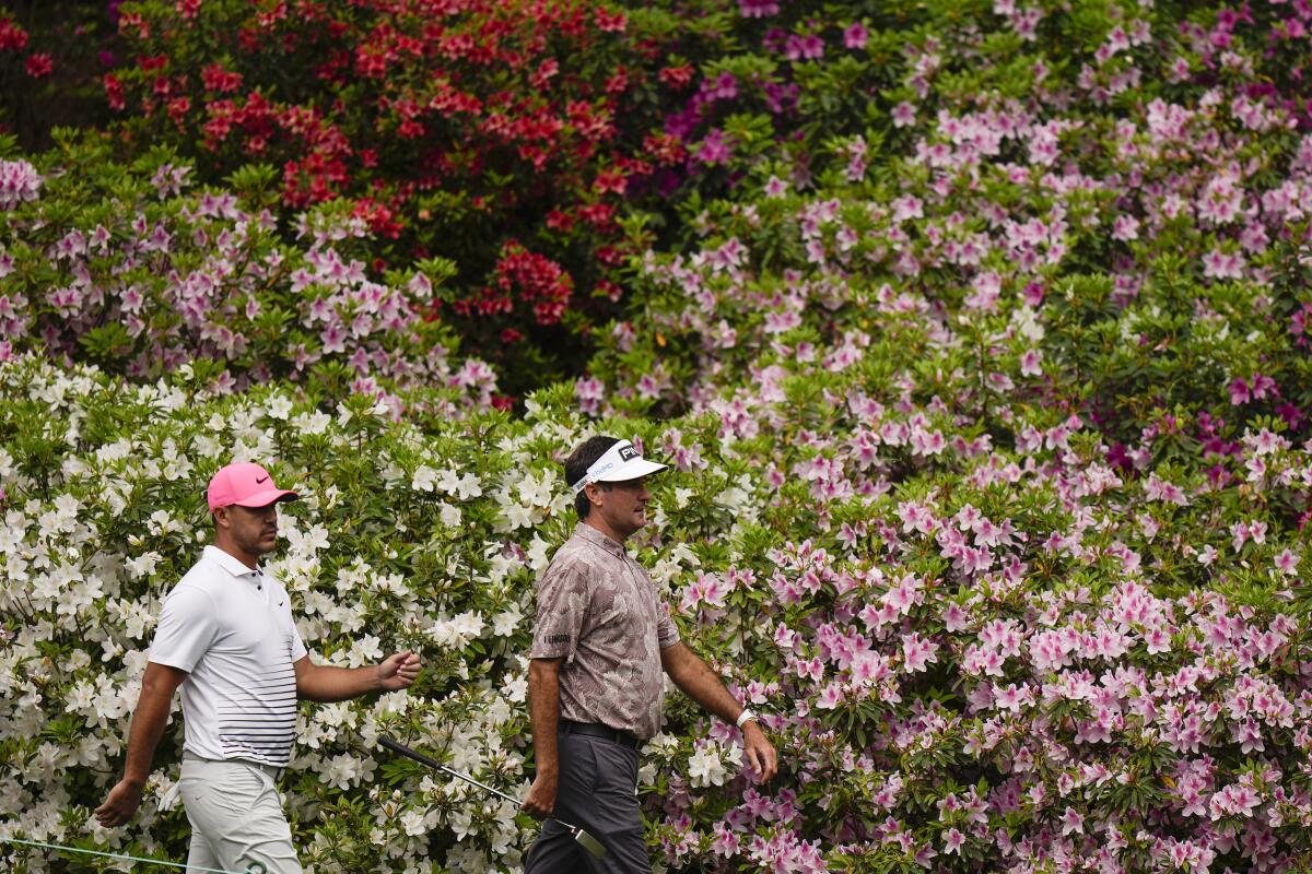 Brooks Koepka and Bubba Watson, right, walk down to the sixth green during the second round of the Masters golf tournament on Friday, April 9, 2021, in Augusta, Ga. (AP Photo/Matt Slocum)