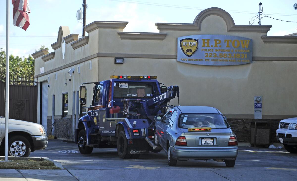 A car is towed into the lot at H.P. Tow in Huntington Park earlier this year. A federal grand jury has indicted one of the company's owners.