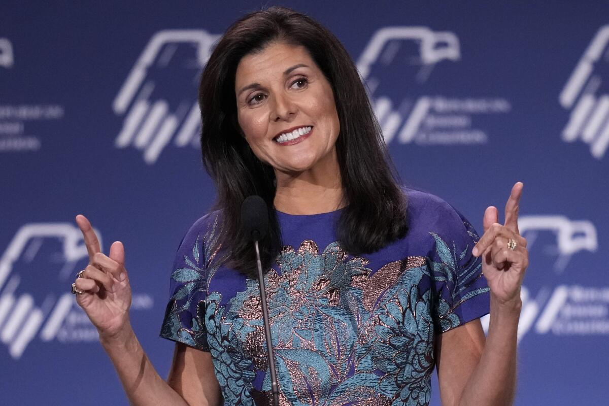 Nikki Haley smiles and points her fingers skyward onstage