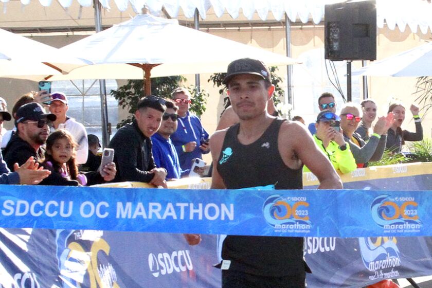 Steven Martinez of San Diego crosses the finish line at the SDCCU OC Marathon.