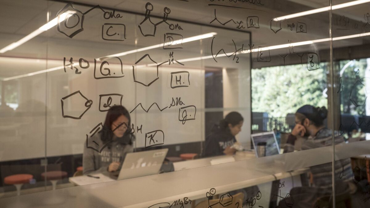 Writable glass walls at Moffitt Library allow classmates to collaborate on problems without wasting paper.