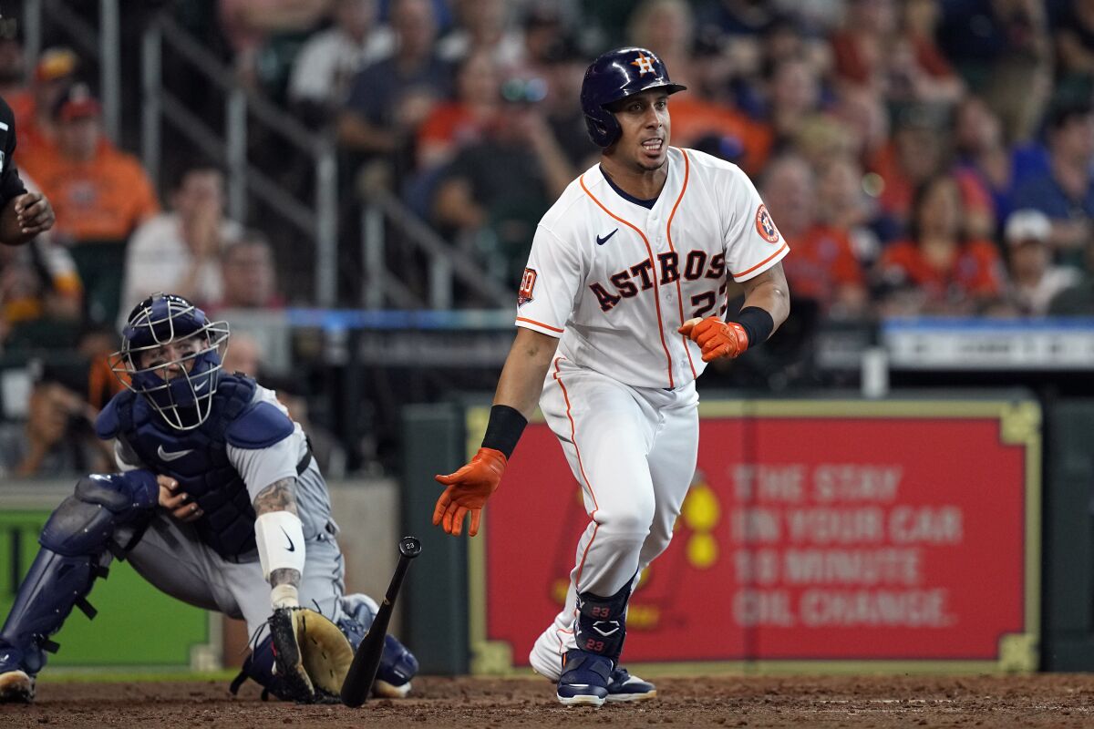 Houston Astros' Michael Brantley (23) hits an RBI-triple as Detroit Tigers catcher Tucker Barnhart watches during the eighth inning of a baseball game Saturday, May 7, 2022, in Houston. (AP Photo/David J. Phillip)