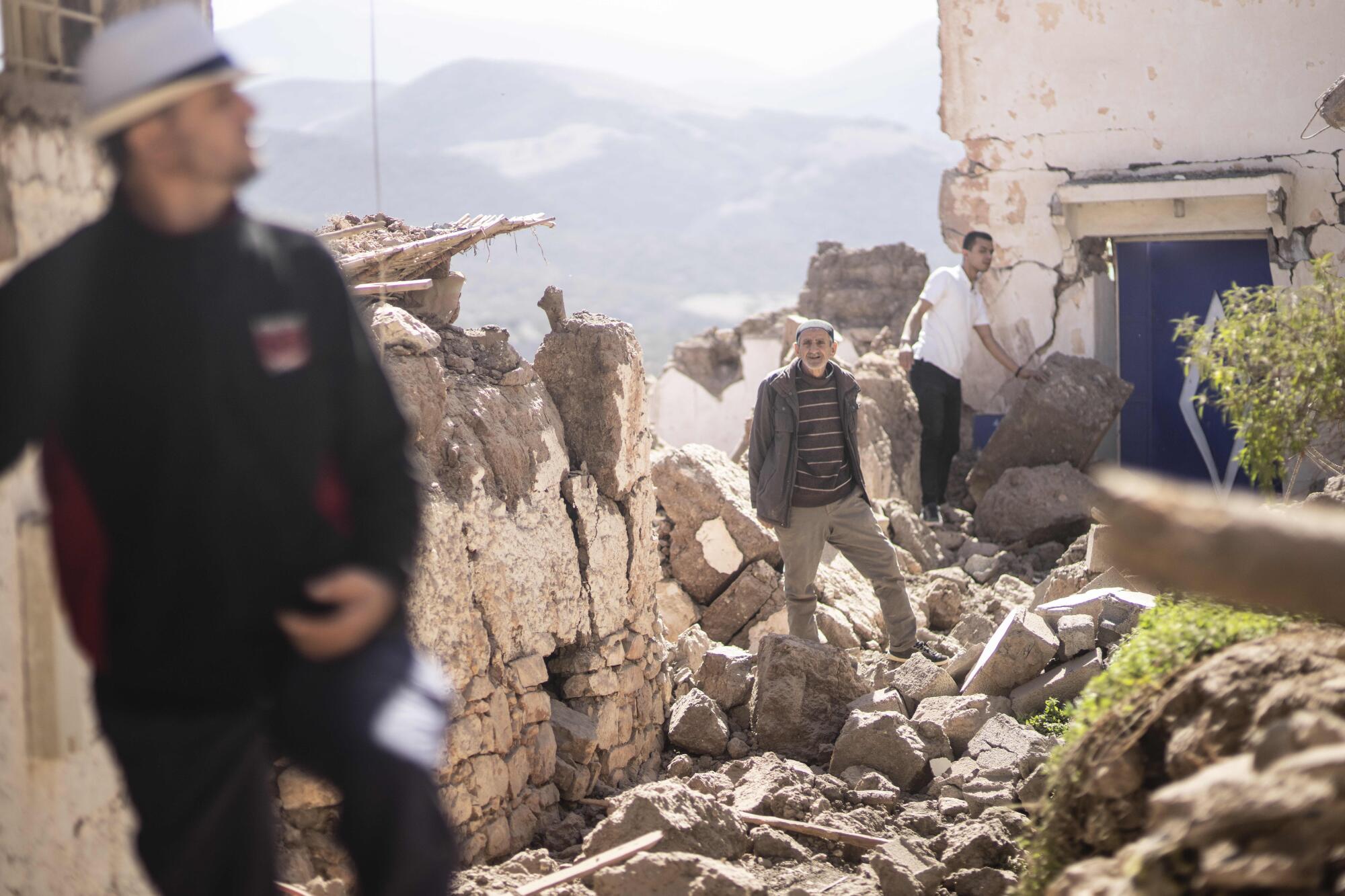 People inspect their damaged homes after an earthquake in Moulay Brahim village on Saturday