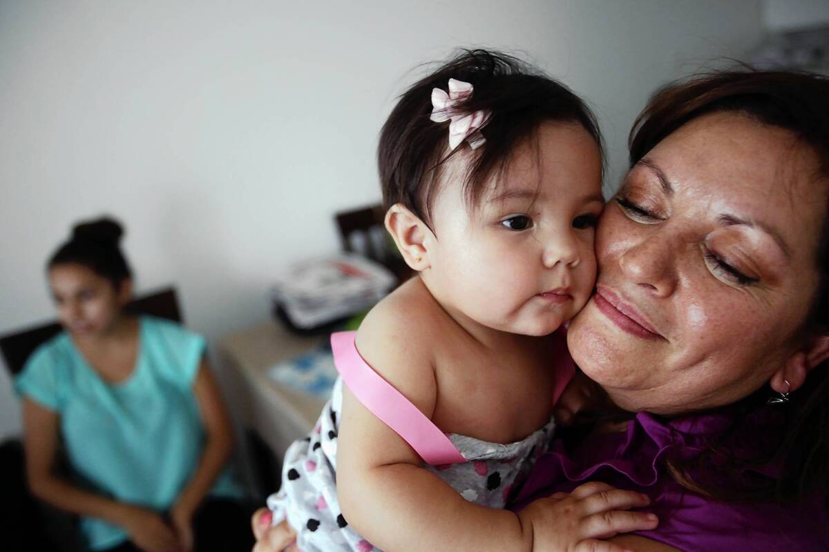 Susana Garcia snuggles with her granddaughter, 9-month-old Phia Garcia. With earnings of less than $13 an hour, she sees herself as part of the lower class.