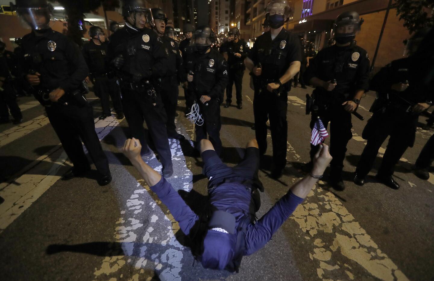A protester remains defiant after being pushed to the ground by police on Grand Avenue in downtown L.A.