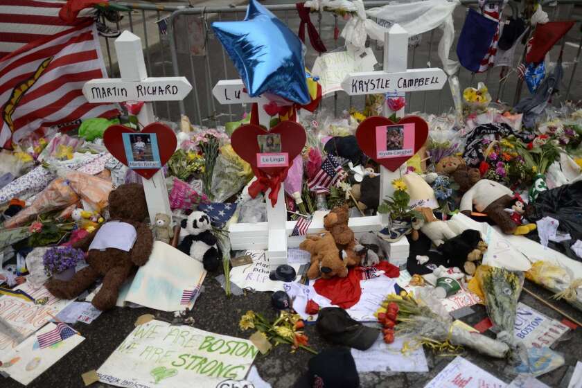 In this April 20, 2013, photo, mememtos and crosses decorate a makeshift memorial on Boylston Street, near the scene of Boston Marathon bombing.