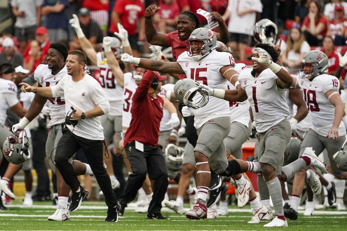 Washington State players celebrate after an NCAA college football game against WisconsinSaturday, Sept. 10, 2022, in Madison, Wis. Washington State won 17-14. (AP Photo/Morry Gash)