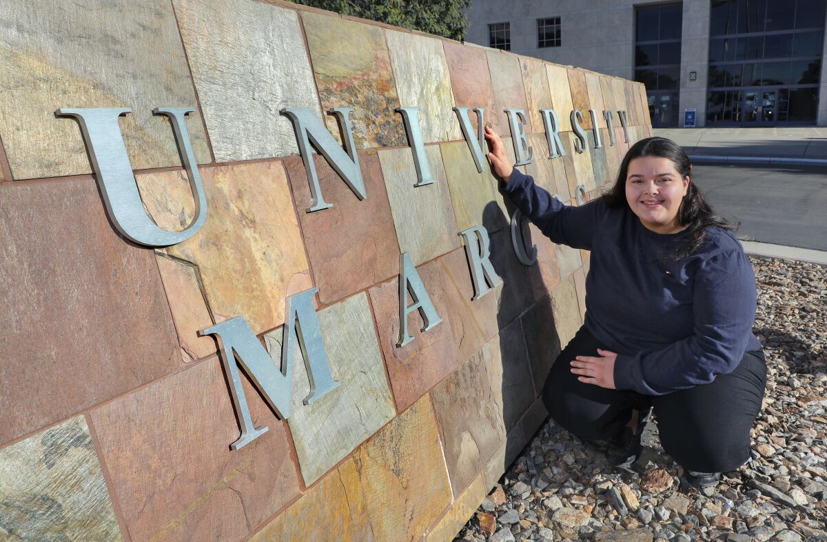 Cal State San Marcos student Brittney Hansen at the school's main sign in front of the Craven Hall administration building.