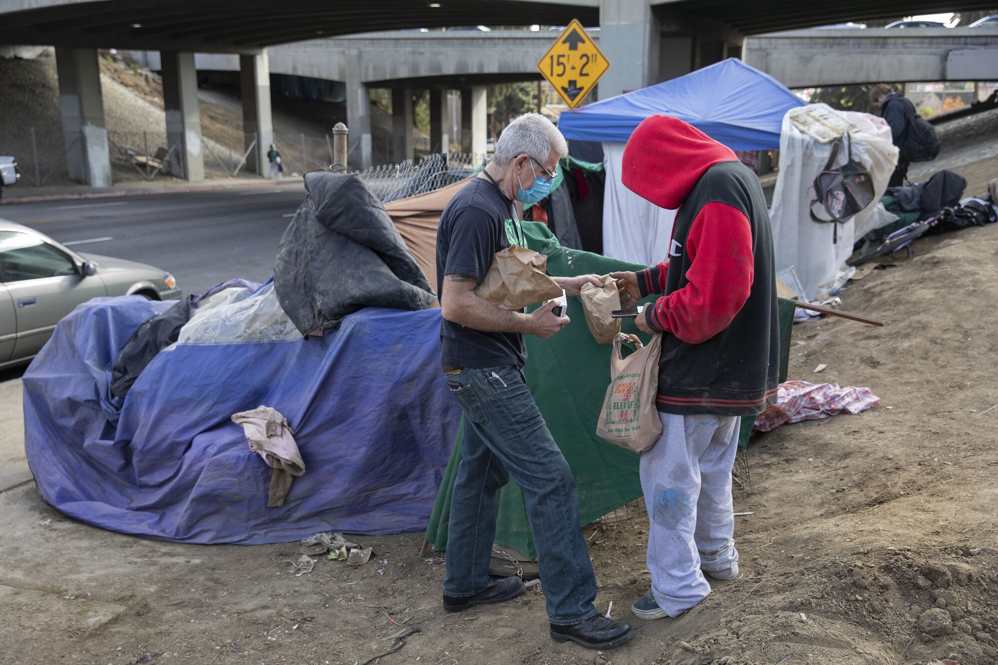 Jason Sodenkamp hands a care package to a client at a homeless encampment. 