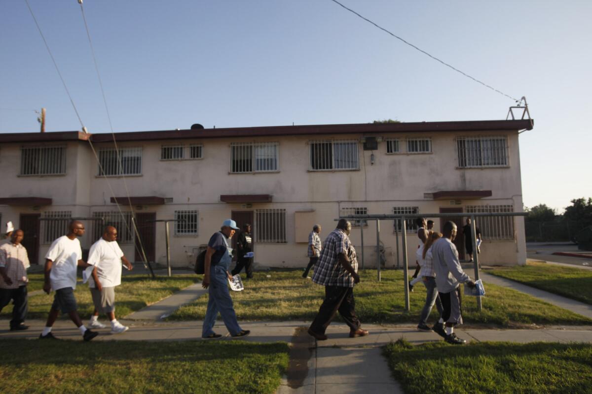 Members of Project Fatherhood walk through Jordan Downs in Watts to help spread the word about their program.