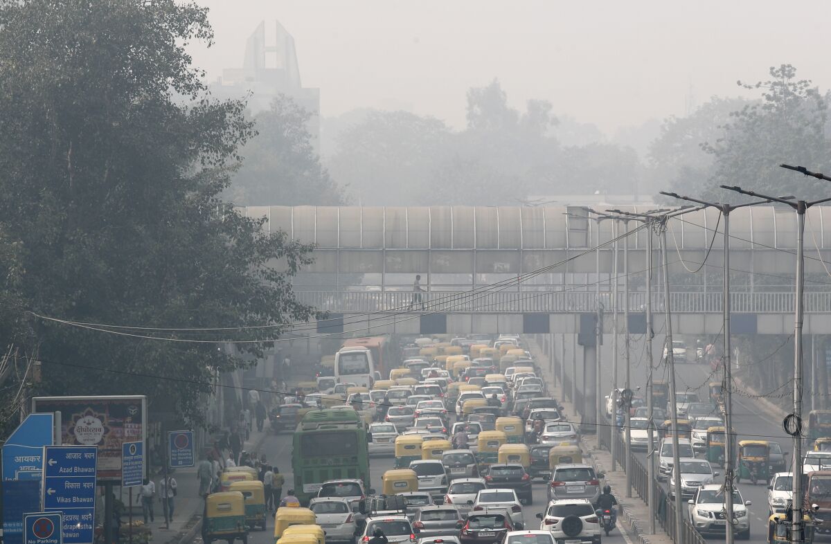 FILE - A pedestrian walks on a bridge above vehicle traffic in New Delhi, India, Tuesday, Nov. 12, 2019, as the city is enveloped under thick smog. The air quality index exceeded 400, about eight times the recommended maximum. A study released on Tuesday, May 17, 2022, blames pollution of all types for 9 million deaths a year globally, with the death toll attributed to dirty air from cars, trucks and industry rising 55% since 2000. (AP Photo/Manish Swarup, File)